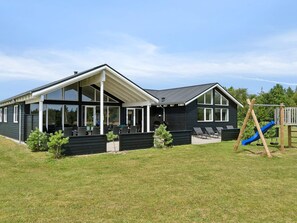 A modern two-story house with a covered patio and a children's play area. - 5 Star Holiday Home in Albaek (Aalbaek)