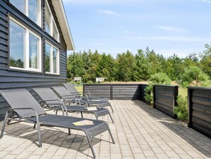 A patio with outdoor seating and a wooden fence. - 5 Star Holiday Home in Albaek (Aalbaek)