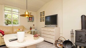 Una sala de estar acogedora con un sofá, un televisor, una chimenea y una mesa de comedor.