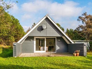 A modern, single-story building with a triangular roof, large glass doors, and a satellite dish. - Tranquil Holiday Home in Ringkøbing near Sea (Ringkobing)
