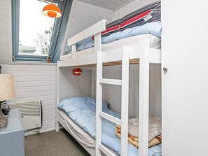 A bunk bed room with a window, a heater, and a lamp. - Tranquil Holiday Home in Ringkøbing near Sea (Ringkobing)