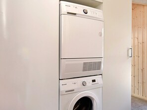 A Brandt washing machine with a front-loading door, control panel, and a dryer below it.