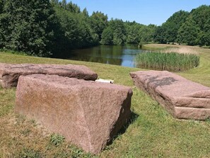 A natural landscape with a body of water, grassy areas, and large rocks. - 4 Star Holiday Home in Bogense (Bogense)