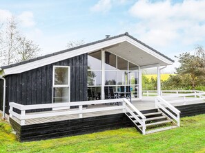 A modern house with a large deck, a covered porch, and a staircase leading to the entrance. - 6 Person Holiday Home in Fjerritslev-by Traum (Fjerritslev)