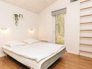 A bedroom with a bed, bedside lamps, a window, and a plant. - 8 Person Holiday Home in Hadsund-by Traum (Hadsund)