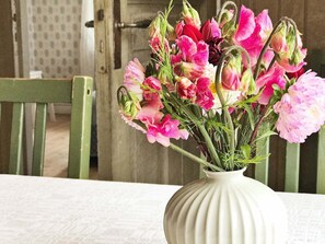 Un vase blanc orné de fleurs roses et rouges, posé sur une table.