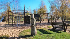 A playground with climbing structures, a slide, and a bench.