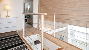 A modern interior with a wooden ceiling, a staircase, and a view of the outside.