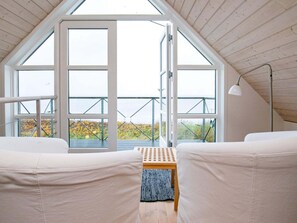 A room with a sloped ceiling, large windows, a wooden bench, and a white sofa. - 6 Person Holiday Home in Brenderup Fyn-by Traum (Middelfart)