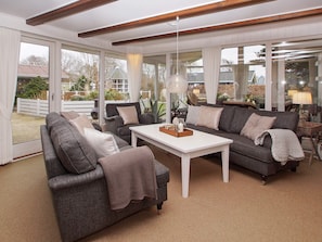 A modern living room with a white coffee table, two grey sofas, and a large window offering a view of the outdoors. - 5 Star Holiday Home in Hemmet (Hemmet)