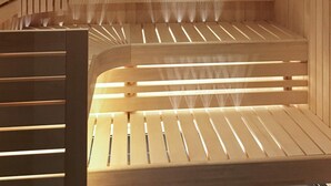Una sauna de madera con bancos de madera y un respiradero visible.
