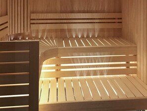 A wooden sauna with slatted benches and a visible steam vent.