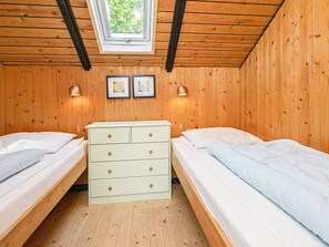 A room with two beds, a dresser, and a skylight. - 4 Person Holiday Home in Oksbol (Oksbol)