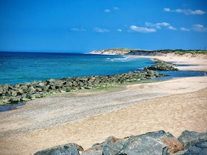 A coastal beach with a rocky breakwater, sandy shore, and a clear blue sky. - 5 Person Holiday Home in Vestervig-by Traum (Vestervig)
