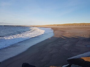 A beach with a rocky shoreline and a clear sky. - 5 Person Holiday Home in Vestervig-by Traum (Vestervig)