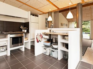Une cuisine moderne dotée d’un four encastré, d’un réfrigérateur et d’un plan de travail en bois.