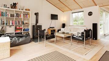 A modern living room with a fireplace, bookshelves, a sofa, and a television.
