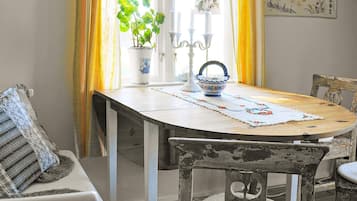 A dining table with a placemat, a potted plant, and a candle holder.