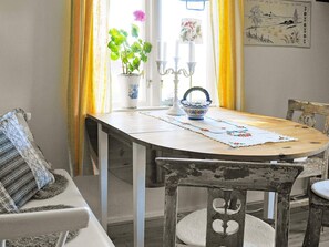 A dining table with a placemat, a potted plant, and a candle holder.