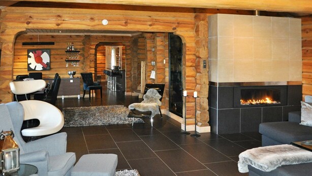 A cozy living room with a fireplace, comfortable seating, and a dining area.