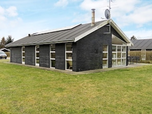 A black building with a sloped roof, large windows, and a chimney. - 8 Person Holiday Home in Hals-by Traum (Hals)