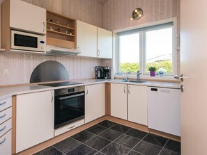 A modern kitchen with a built-in oven, microwave, and coffee maker. - Pleasing Holiday Home in Haderslev near Sea (Haderslev)