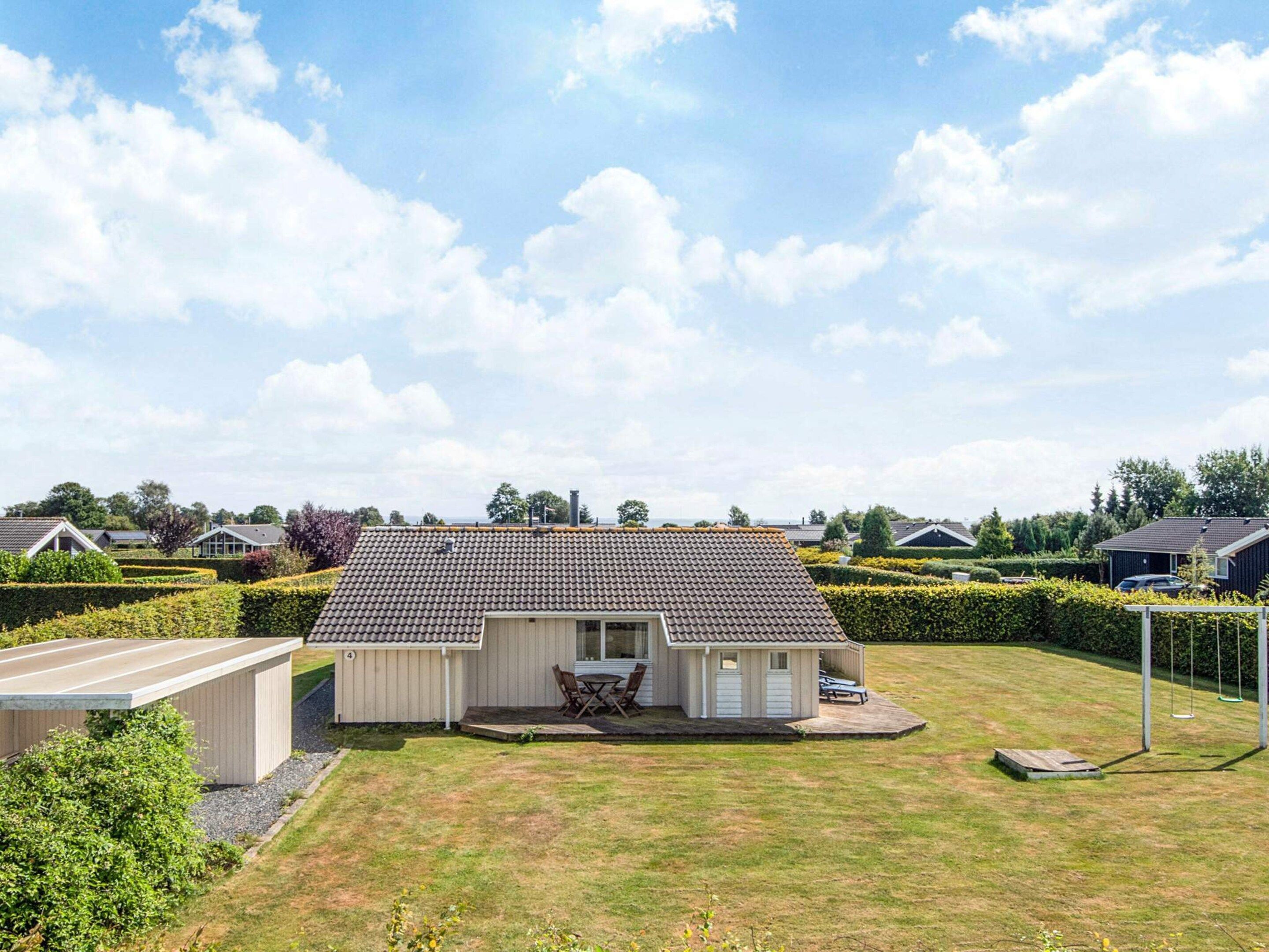 A single-story house with a tiled roof, a front porch, and a small deck.