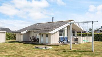 A single-story house with a covered patio, a small deck, and a swing set.