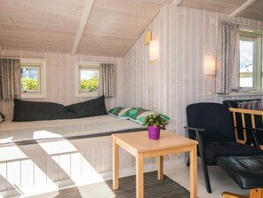A cozy room with a bed, a wooden table, a chair, and a window with curtains. - Pleasing Holiday Home in Haderslev near Sea (Haderslev)