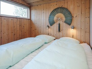 A room with wooden walls, two beds with white bedding, a large fan, and two wall-mounted lights. - Spacious Holiday Home in Hejls near Sea (Hejls)