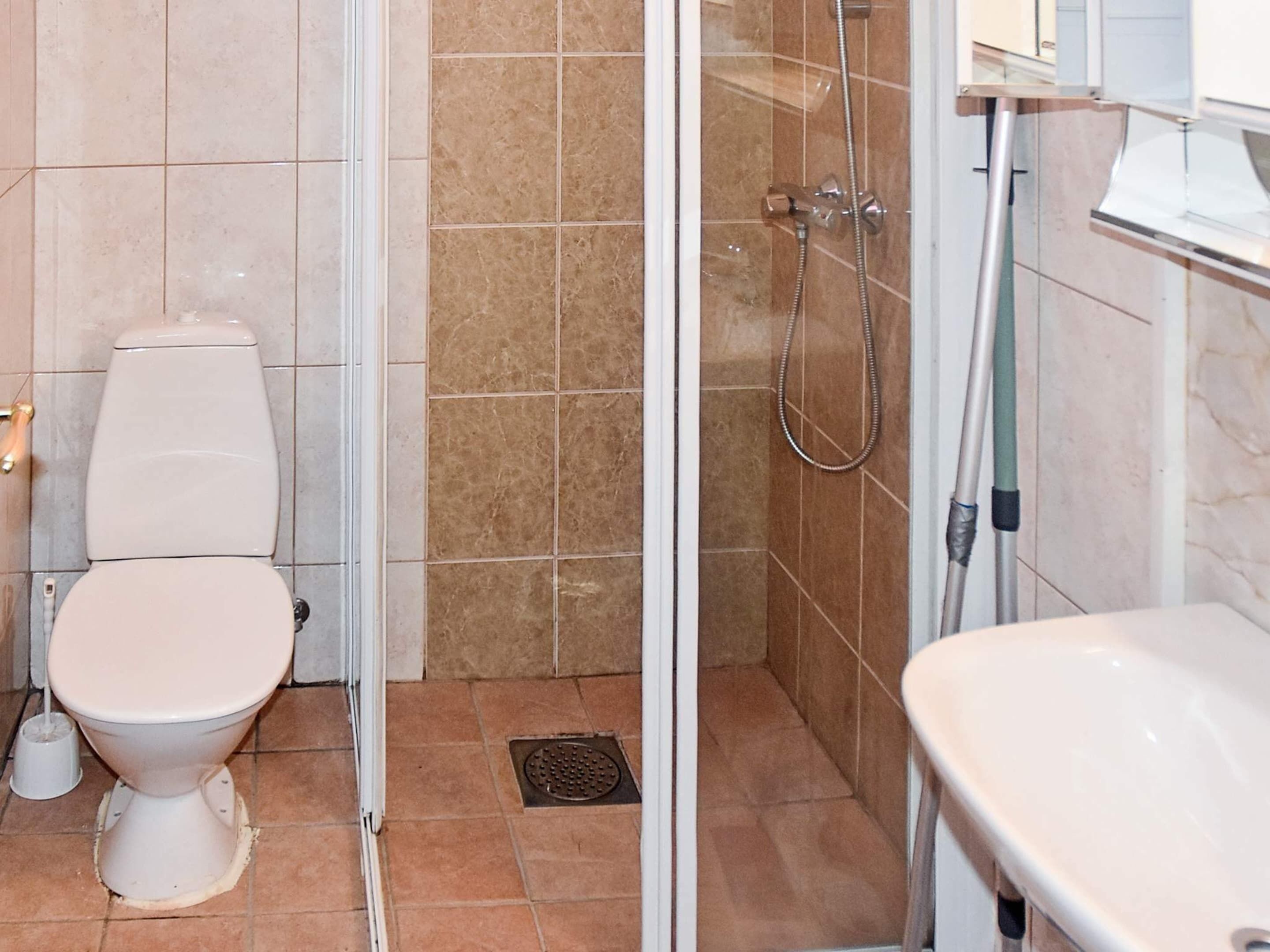 Une salle de bain avec des toilettes, une douche et un lavabo.