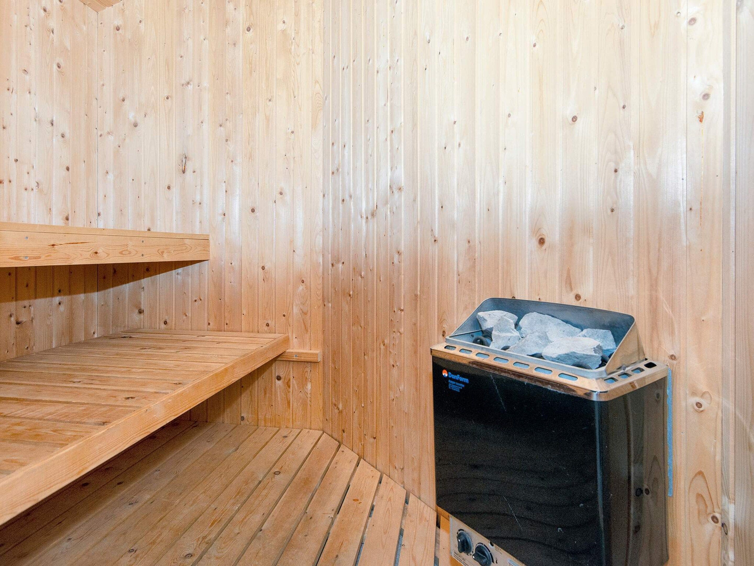 A sauna room with wooden walls and a bench.