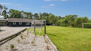 Il s’agit d’une propriété résidentielle comprenant une maison, un patio couvert, une cour clôturée et un poteau de but de football.