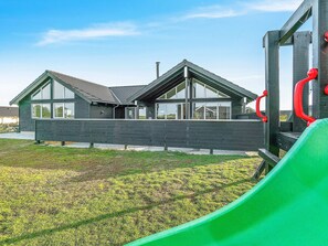 A modern two-story house with large windows and a sloped roof. - 5 Star Holiday Home in Bogense (Bogense)