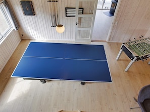 A room with a ping pong table, a foosball table, and a door with a window. - 5 Star Holiday Home in Bogense (Bogense)