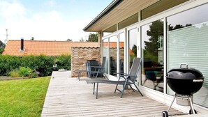A patio with a barbecue grill, outdoor furniture, and a view of a brick building. - 5 Star Holiday Home in Sydals (Sydals)