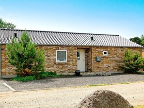 A single-story brick building with a tiled roof, a front door, and a small window. - 5 Star Holiday Home in Sydals (Sydals)