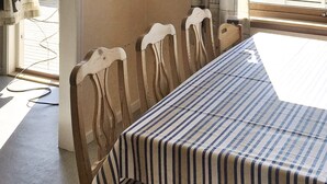 A dining table with a striped tablecloth, surrounded by wooden chairs with curved backs. - 6 Person Holiday Home in Dyrvik (Frøya)