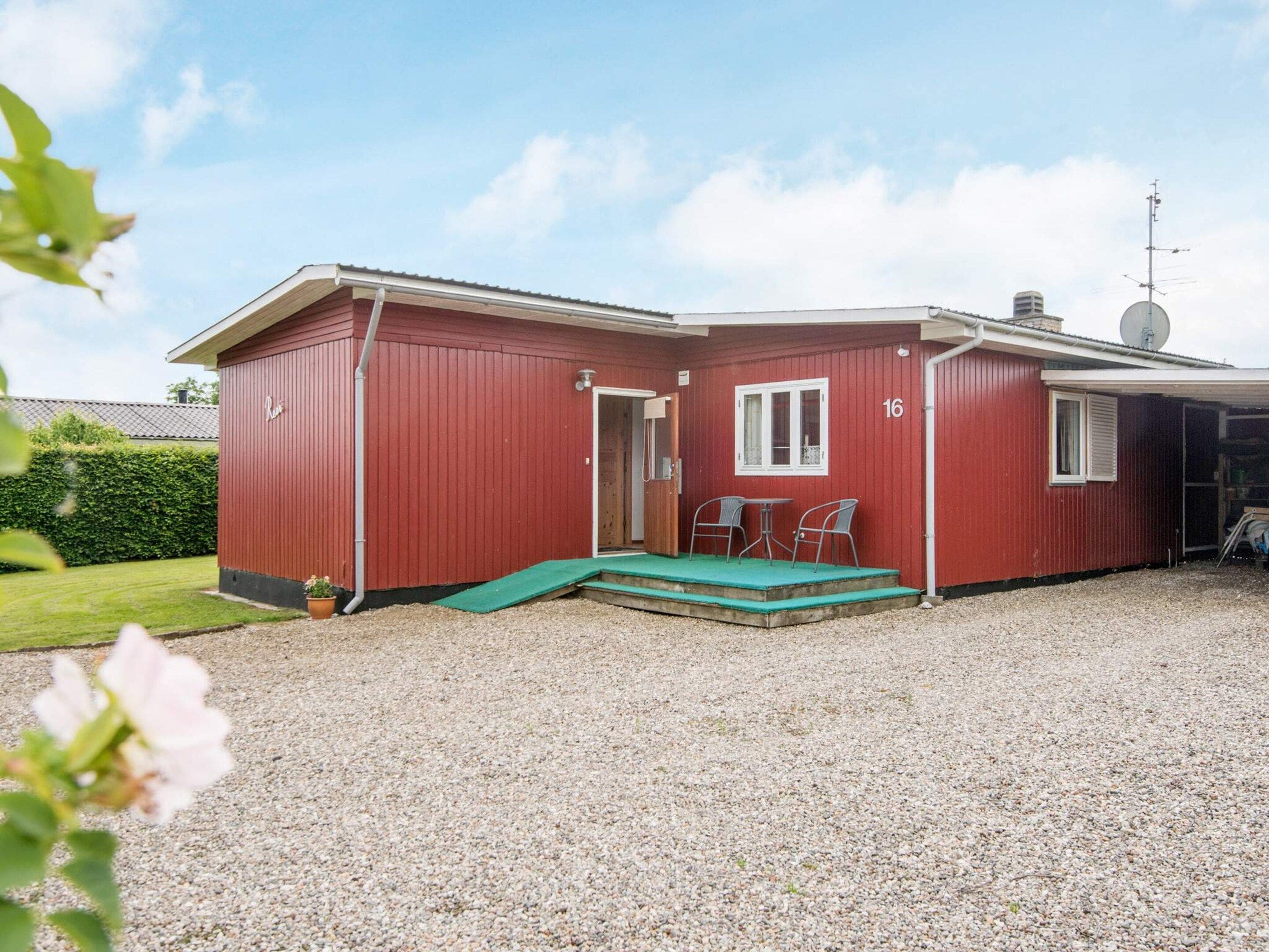 A red building with a covered patio, a door, and a window.