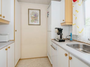 A compact kitchen with white cabinets, a coffee maker, and a sink. - 4 Person Holiday Home in Haderslev-by Traum (Haderslev)