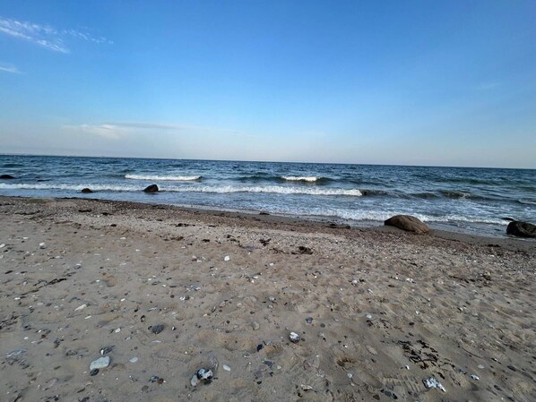 A beach with pebbles and rocks, a clear sky, and calm waves. - 4 Person Holiday Home in Haderslev-by Traum (Haderslev)