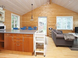 A cabin interior with a kitchen, dining area, and living room.