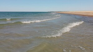 A beach with clear water and a sandy shore.