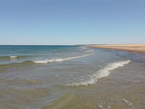 A beach with clear water and a sandy shore.