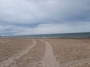 A sandy beach with a visible path leading to the water.