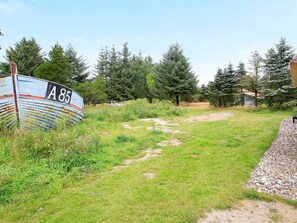 A grassy area with a large blue sign marked 'A85' and a path leading through it. - 7 Person Holiday Home in Fjerritslev (Fjerritslev)