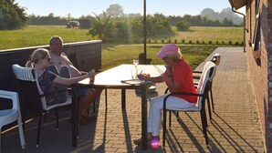 A patio with a brick floor, outdoor furniture, and a table with a drink. - 8 Person Holiday Home in Sydals-by Traum (Sydals)