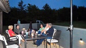 A group of people seated around a table with chairs, a table lamp, and a bottle on the table. - 8 Person Holiday Home in Sydals-by Traum (Sydals)
