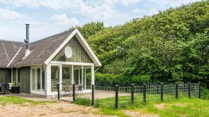 Un chalet rustique doté d’une grande cheminée, d’un porche abrité et d’un espace extérieur clôturé.