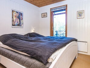 A bedroom with a bed, a window, and wall-mounted artwork. - 6 Person Holiday Home in Glesborg-by Traum (Glesborg)